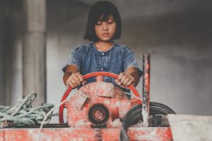 繊維業で働く児童労働の少女