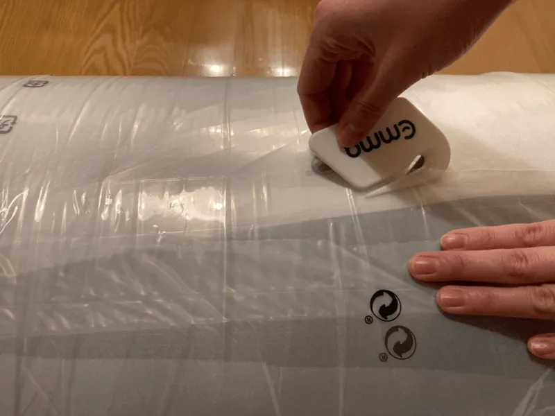 付属のカッターでエママットレスのビニールを開封する様子
